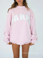 Annabelle | Damska oversize'owa bluza varsity, sweter z naszywką szenilową i okrągłym dekoltem | Rokishi | Biały z szałwiowymi literami