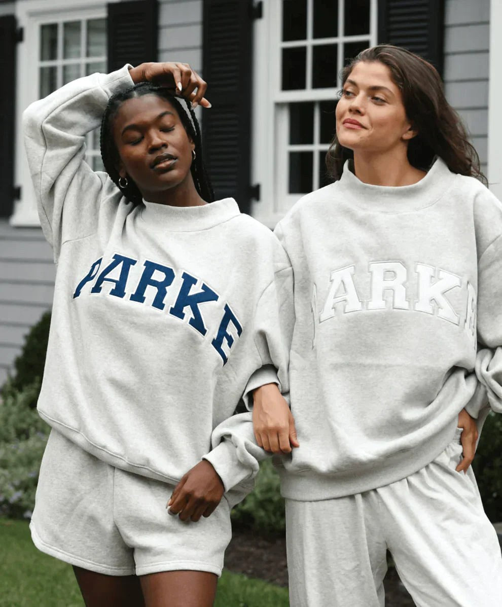 Annabelle | Damska oversize'owa bluza varsity, sweter z naszywką szenilową i okrągłym dekoltem | Rokishi | Delikatny róż z białymi literami