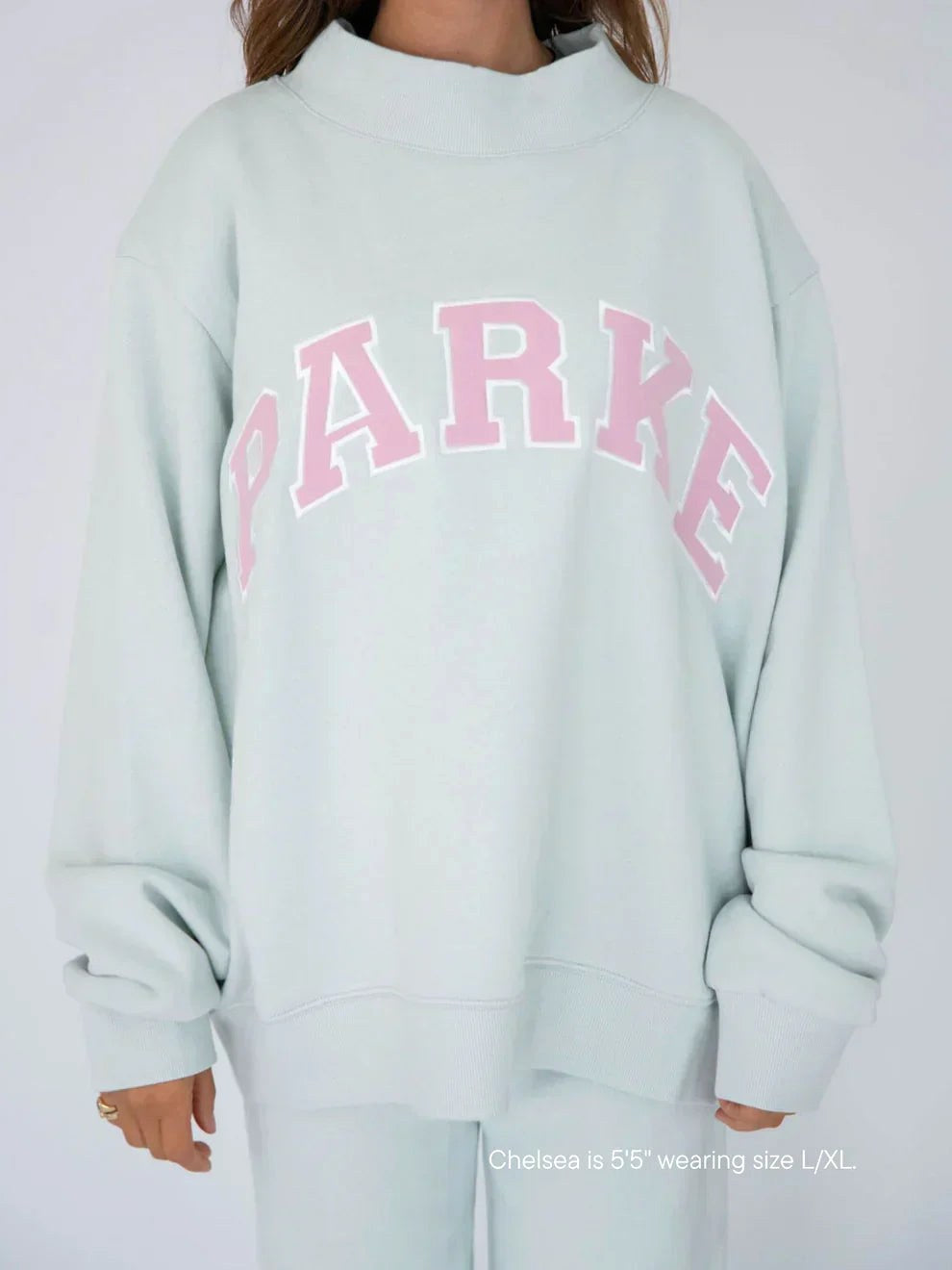 Annabelle | Damska oversize'owa bluza varsity, sweter z naszywką szenilową i okrągłym dekoltem | Rokishi | Biały z szałwiowymi literami